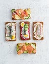 Savory fish smorrebrod, set of five traditional Danish sandwiches. Black rye bread with anchovy, beetroot, radish, eggs, salmon,