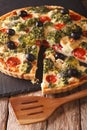 Savory food: sliced tart with chicken, broccoli, tomatoes and olives close-up. vertical