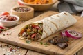 Savory Meat Wrap on Wooden Table Close-Up - generated by ai Royalty Free Stock Photo