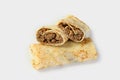 Savory pancake rolls stuffed with ground meat. White background, copy space. One pancake is shown in the section with the filling Royalty Free Stock Photo