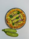 savory pie with courgettes and basil on a round plate, italian plate