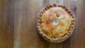 Whole 9 inch Celebration Pork Pie Delights on Rustic Wooden Table top view Royalty Free Stock Photo