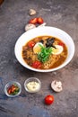 Savory Ramen Bowl with Colorful Fresh Ingredients on Dark Background