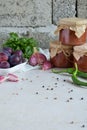 Savory sauce from red plums, garlic, cilantro, dill and hot pepper. Georgian tkemali on white background. Autumn canning and prese