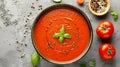 Savory Simplicity: A delectable bowl of homemade tomato soup, captivating in top view on a sleek gre