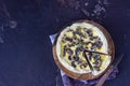 Savory tart, pie or quiche with mushrooms and cheese on wooden plate, dark brown textured background. Homemade savory autumn Royalty Free Stock Photo