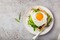 Savory waffles with avocado, arugula and fried egg for breakfast