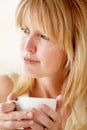 Savouring a good cup of coffee. Attractive woman looking away while enjoying her coffee. Royalty Free Stock Photo