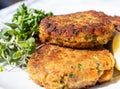 Savoury, crisp and starchy, fishcakes, crab cakes..Fried fish patties served on a plate with salad on the side Royalty Free Stock Photo