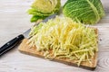 Savoy cabbage cut into strips on a kitchen board, cooking at home with healthy winter vegetables