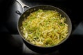 Savoy cabbage in a frying pan on the black stove, cooking at home with healthy winter vegetables