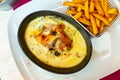 Savoyard escalope with turkey, bacon, reblochon in creamy sauce with fries Royalty Free Stock Photo