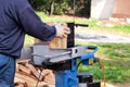 Saw cutting wood for winter. A man cutting firewood for the winter using a modern machine lumber saw. Royalty Free Stock Photo