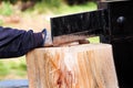 Saw cutting wood for winter. A man cutting firewood for the winter using a modern machine lumber saw. Royalty Free Stock Photo