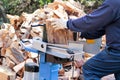 Saw cutting wood for winter. A man cutting firewood for the winter using a modern machine lumber saw. Royalty Free Stock Photo