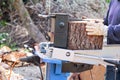 Saw cutting wood for winter. A man cutting firewood for the winter using a modern machine lumber saw. Royalty Free Stock Photo