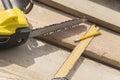 Saw, pencil and a square line on the rafters. Construction of wooden houses and roofs. Royalty Free Stock Photo