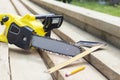 Saw, pencil and a square line on the rafters. Construction of wooden houses and roofs Royalty Free Stock Photo