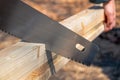 Sawing or cutting a wooden board or bar with a hand saw or hacksaw during carpentry or carpentry work at a construction Royalty Free Stock Photo