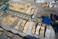 Sawmill aerial view chopped tree wood logs stacks in a row with machinery