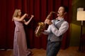 Sax man and woman fiddler duet playing classical melody