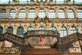 Saxon architecture in Dresden. Saxon Palace Zwinger. Girl posing on the stairs in front of the entrance