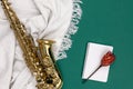 Saxophone on a green background and notepad, top view.