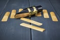 Saxophone mouthpiece and reed with clamp and gold hardware along with replacement reeds on gray wooden background Royalty Free Stock Photo