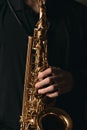 Saxophonist with a beautiful wind musical instrument, musician plays the saxophone, hands close-up, jazz and blues background Royalty Free Stock Photo