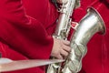 Saxophonist in a red suit close-up. Concept: playing the saxophone, music. Saxophone jazz music instrument Alto sax saxophonist Royalty Free Stock Photo