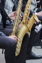 Saxophonists playing in a jazz band, dressed in men& x27;s classic vest and trousers. Close up shoot of hands