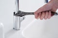 Say goodbye to water wastage. a person repairing a tap with a wrench.
