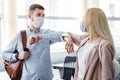 Say hello, social distance and return to work after quarantine. Millennial man and woman in protective masks are touched