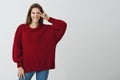 Say hi to new opportunities ahead. Studio shot of good-looking happy woman in trendy loose sweater holding v sign over