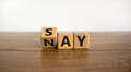 Say nay symbol. Turned a cube, changed the word `say` to `nay`. Beautiful wooden table, white background. Copy space. Business