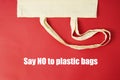 Say No to plastic bag lettering, inscription. . White tote canvas fabric, eco bag cloth shopping sack on colrful red background . Royalty Free Stock Photo