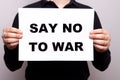 say no to war. No violence. a man holds a poster in his hands with appeals, a message not to use aggression. no war. a Royalty Free Stock Photo