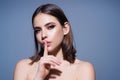 Say secret hush be quiet with finger on lips. Shhh gesture isolated on studio background portrait. Girl showing hush Royalty Free Stock Photo