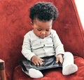 When we say, user friendly we mean it. a little baby boy sitting in a chair holding a digital tablet. Royalty Free Stock Photo