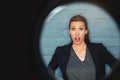 Say whaaat. Portrait of a businesswoman posing against a brick wall with a peephole effect. Royalty Free Stock Photo