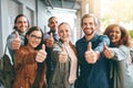 Say yes to furthering your education. Portrait of a group of happy young students giving thumbs up together on campus.