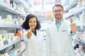 Say yes to good health. Portrait of a confident mature man and young woman showing thumbs up in a pharmacy. Royalty Free Stock Photo