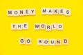 Sayings Money makes the world go round on yellow background.