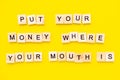 Sayings Put your money where your mouth is on yellow background.