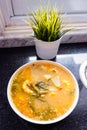 Sayur asem is a popular Indonesian vegetable in tamarind soupÃ¢â¬Å½ with jack fruit, corn, long beans in a white bowl in a kitchen