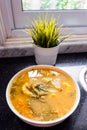 Sayur asem is a popular Indonesian vegetable in tamarind soupÃ¢â¬Å½ with jack fruit, corn, long beans in a white bowl in a kitchen.