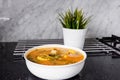 Sayur asem is a popular Indonesian vegetable in tamarind soupÃ¢â¬Å½ with jack fruit, corn, long beans in a white bowl in a kitchen.