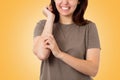 Scabies. Close up portrait of a Caucasian young woman scratching her hand covered in a red rash. Yellow background. Copy space. Royalty Free Stock Photo