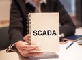 SCADA acronym for Supervisory Control and Data Acquisition text written in a notebook on the office desk