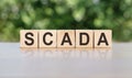 Scada word concept on cubes, gray-green background Royalty Free Stock Photo
